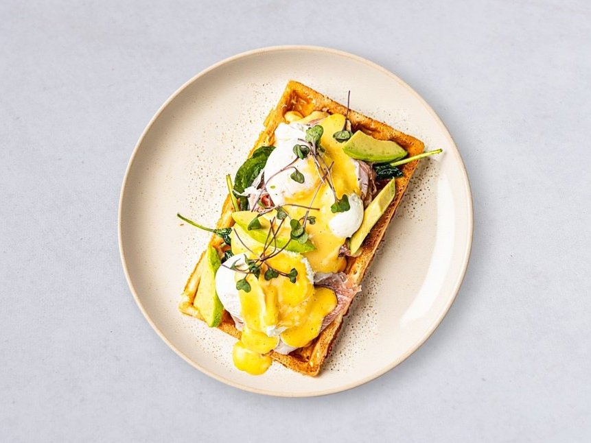 Benedict-style waffle with poached eggs, avocado and prosciutto